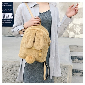 Detail of cute faux fur mini backpack with rabbit ears and plush pompom decoration