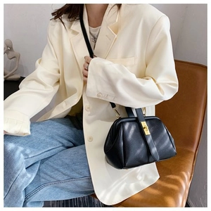 Litchi texture black doctor bag with gold lock shown in a lifestyle indoor setting