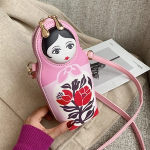 Detail of pink Russian doll crossbody bag showing floral print and gold zipper finish
