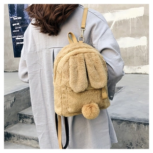 Detail view of khaki faux fur rabbit backpack showing plush ears and leather straps