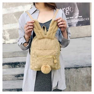 Close-up of khaki plush rabbit backpack with long ears and zipper pocket detail