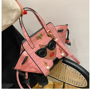 Pink croc-embossed wing bag featuring fashion portrait print and pearl pendant detail