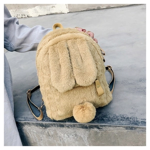 Detail showing plush rabbit ears and a round pom-pom tail on a soft faux fur backpack