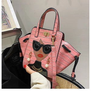 Detail of pink croc-effect handbag featuring a cartoon portrait with faux pearl earrings