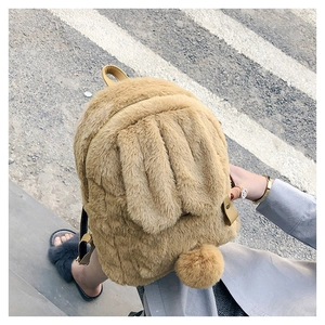 Close-up of soft faux fur rabbit backpack with long ears and brown leather straps