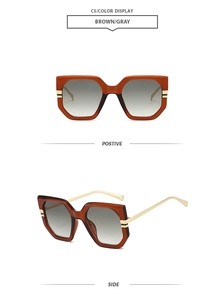 Detail of oversized brown polygon sunglasses with grey gradient lenses and gold metal temples