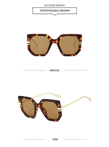 Detail view of tortoiseshell oversized sunglasses with gold metal temples and brown lenses