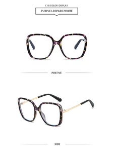 Detail view of purple tortoiseshell square frames with gold metal temples on sunglasses