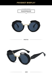 Detailed view of geometric thick black frames with blue lenses and gold metal nose bridge