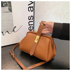 Detailed view of the brown vintage leather texture and golden metal twist lock on the handbag