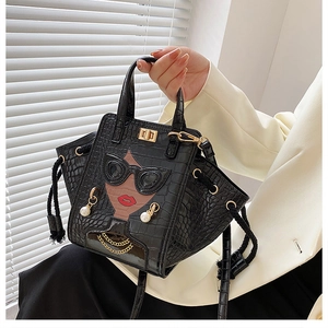 Detail of crocodile pattern handbag with sunglasses, red lips, and pearl drop charms