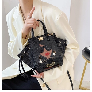 Detail of crocodile pattern bag with chic woman graphic and 3D pearl accessories
