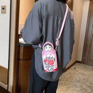 Pink Russian doll crossbody bag in PU leather shown on person for size perspective