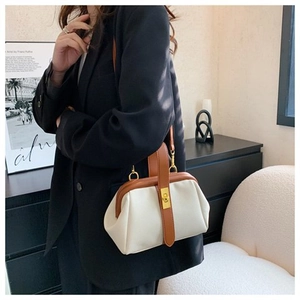 Close-up of vintage-style cream and brown doctor bag with retro gold clasp and leather texture