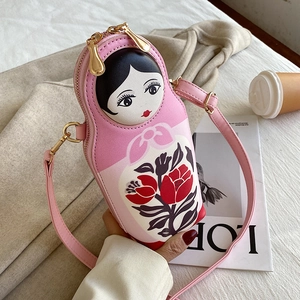 Detail of pink Russian doll crossbody bag showing the PU leather texture and gold zippers