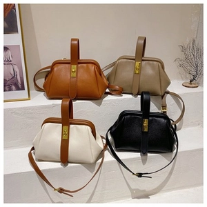 Detail view of four vintage doctor bags in caramel and black on decorative display