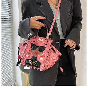 Detail of pink crocodile pattern handbag with cartoon girl design and pearl embellishments