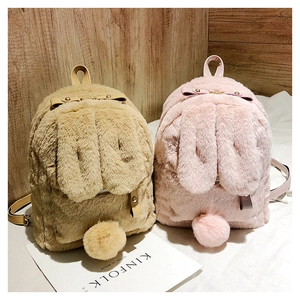 Detail of plush bunny ear backpacks in khaki and pink with fluffy texture and bow accents