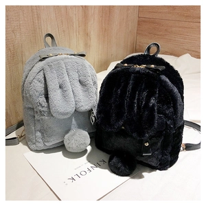 Detail of cute faux fur rabbit backpacks with bunny ears and pom-pom tails in grey and black