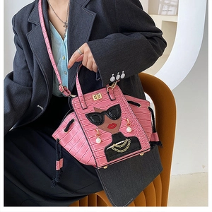 Detail of pink crocodile embossed bag featuring a cartoon girl print and metal chain