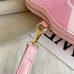 Detailed close-up of pink Russian doll PU bag with gold metal hardware and stitching