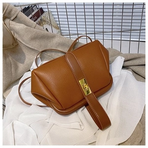 Close-up of caramel litchi grain leather bag with a gold metal twist lock and buckle