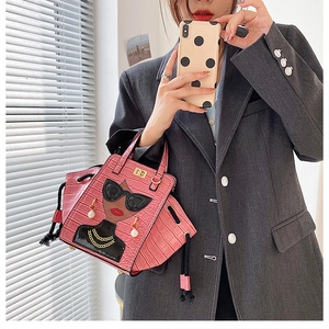 Detail of pink croc-embossed handbag featuring a chic lady cartoon and pearl earrings
