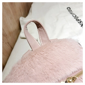 Close-up of pink faux fur texture and leather handle on a cute plush backpack