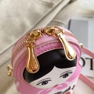 Detail of pink Russian doll PU bag showing gold dual metal zippers and cute face print