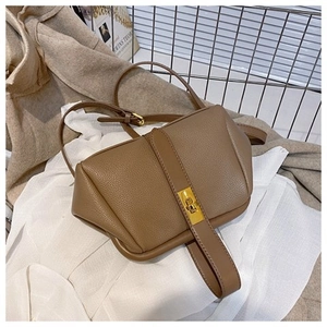 Detail view of mocha brown leather shell bag with gold lock and litchi texture