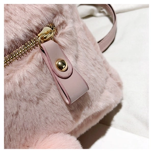 Macro view of pink faux fur texture with gold metal zipper and faux leather puller