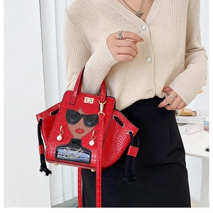 Detail of red crocodile texture handbag with unique fashion girl embroidery and pearls
