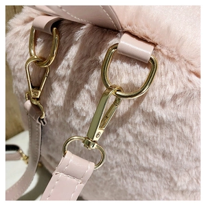 Detail of pink faux fur backpack featuring gold metal hooks and durable PU leather straps