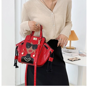 Detail of red crocodile texture handbag featuring a stylish girl design with sunglasses