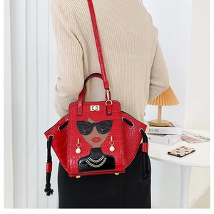 Detail of red croc-effect bag with cartoon lady and side drawstring on model