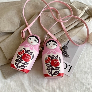 Detail of pink PU leather Russian nesting doll crossbody bag with floral patterns