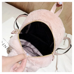 Detailed interior of pink faux fur backpack showing brown lining and pocket