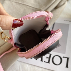 Pink pebbled leather crossbody bag showing internal brown fabric lining and zip opening