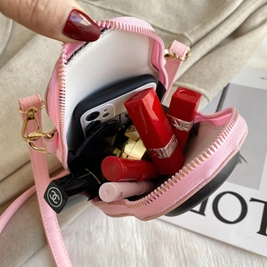Pink doll crossbody bag interior view showing space for phone, lipstick and compact