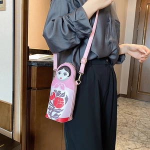 Detailed view of pink Russian nesting doll crossbody bag featuring floral print pattern