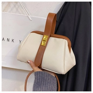 Detail of doctor style bag with cream lychee leather and brown trim and gold lock