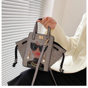 Detail of grey crocodile pattern bag with portrait illustration and 3D pearl earring
