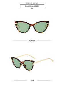 Detail view of tortoiseshell cat-eye sunglasses with green lenses and gold temples