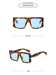Detail view of tortoiseshell square sunglasses with thick frames and light blue lenses