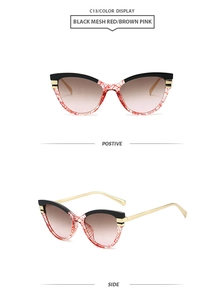 Detail of cat eye sunglasses with red mesh pattern frames and gradient brown pink lenses