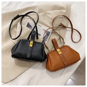 Litchi pattern leather shell bag with gold clasp shown in black and brown colors