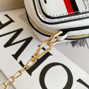 Detail of white leather cassette bag with gold chain strap and red-black striped webbing
