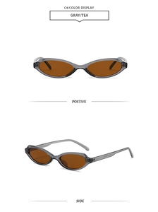 Detail view of narrow cat-eye sunglasses with translucent gray frames and tea lenses