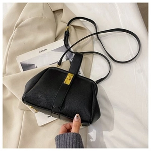 Top view of black lychee grain leather handbag with gold metal clasp on white background