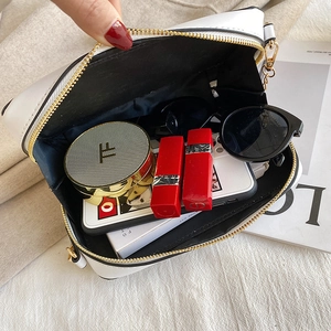 Detail view showing the spacious interior of the cassette crossbody bag with daily essentials